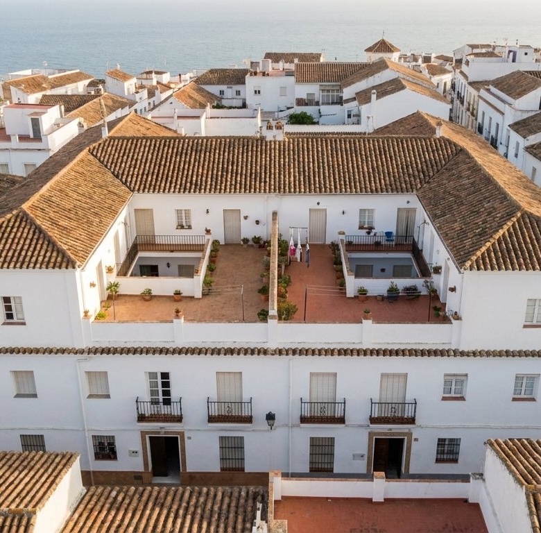 Casa andaluza encalada con patio central dividida en dos viviendas independientes